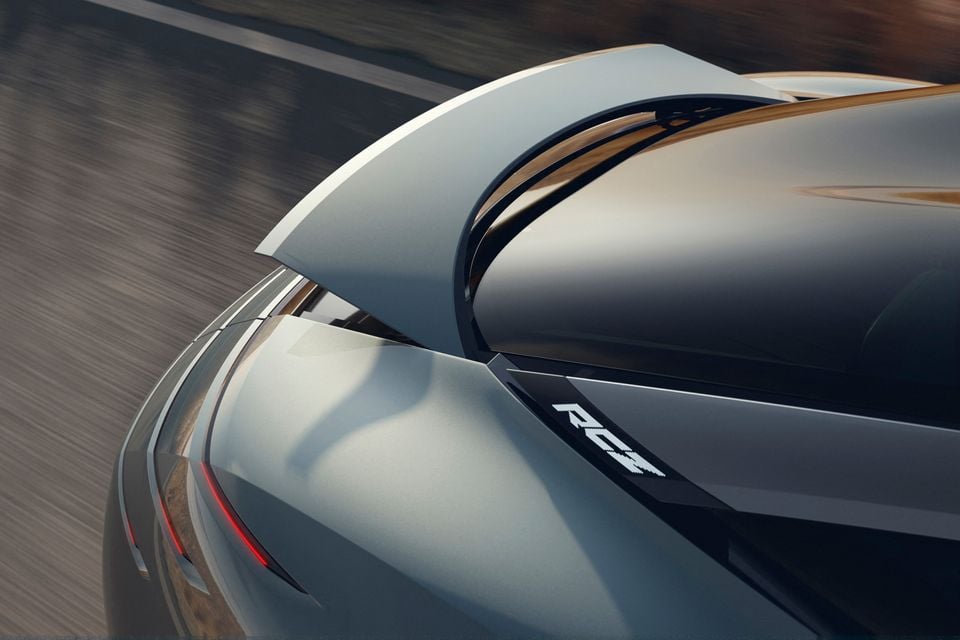 Close-up of the rear of the Peugeot Vision RCZ concept in motion, showing its large rear spoiler, red tail-light strips and illuminated RCZ badge