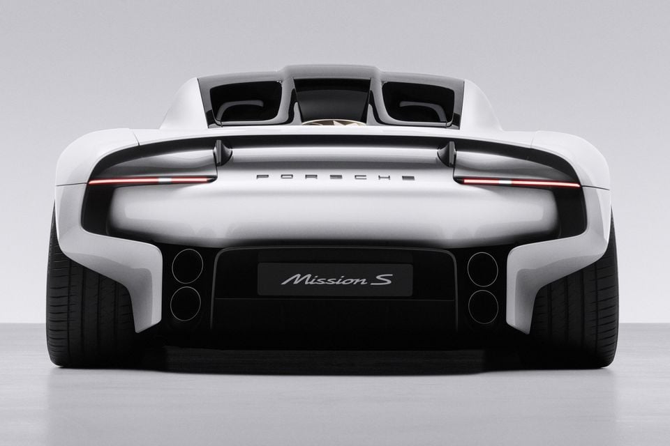 Rear view of a white Porsche Mission S concept with full-width tail-lights and Mission S lettering, shown in a studio