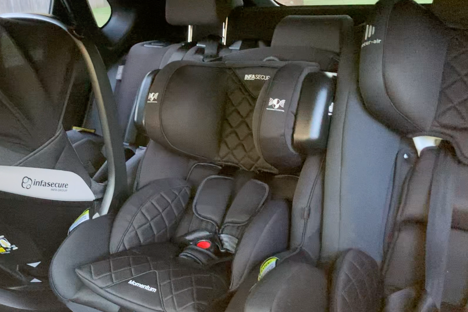 Three child car seats installed across the rear seat of a car, including Infasecure and Momentum branded seats