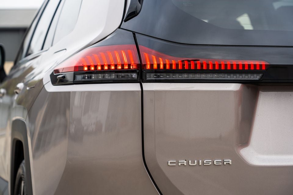 Close-up of the rear taillight and 'Cruiser' badge on a beige 2026 Toyota RAV4 Cruiser.