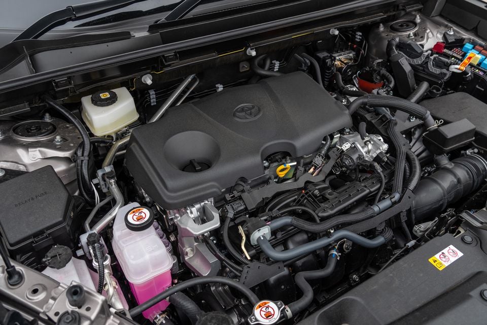 The engine bay of a 2026 Toyota RAV4 Cruiser, showing the Toyota-branded engine cover, pink coolant reservoir, and surrounding components