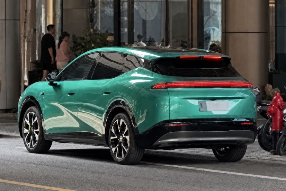 A teal green Xpeng L05 SUV seen from the rear three-quarter angle, parked on a city street
