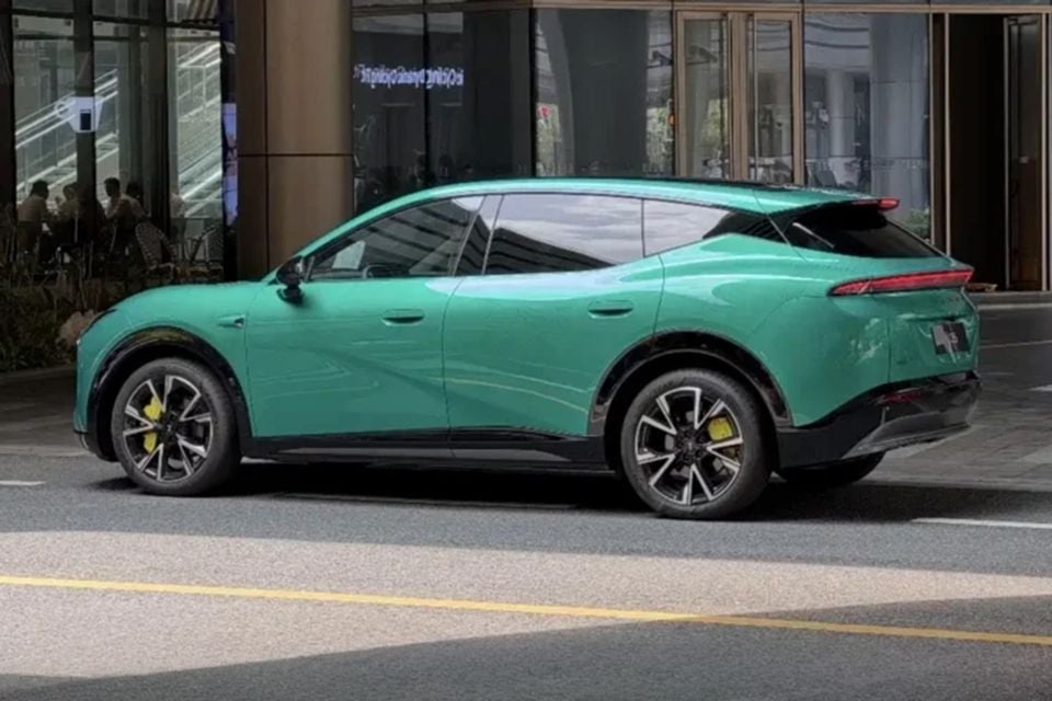 A green XPeng Mona L05 SUV seen from the rear three-quarter angle on a city street