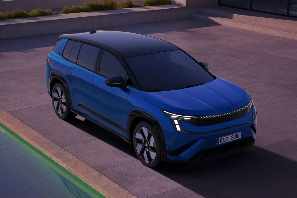 A blue 2026 Skoda Peaq SUV with a black roof seen from a front three-quarter elevated angle, parked on a tiled surface at dusk.