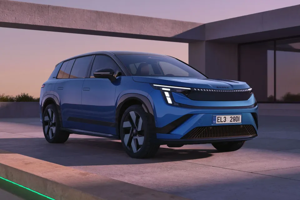 A blue Skoda Elroq SUV seen from the front-side angle, parked on a concrete surface at dusk