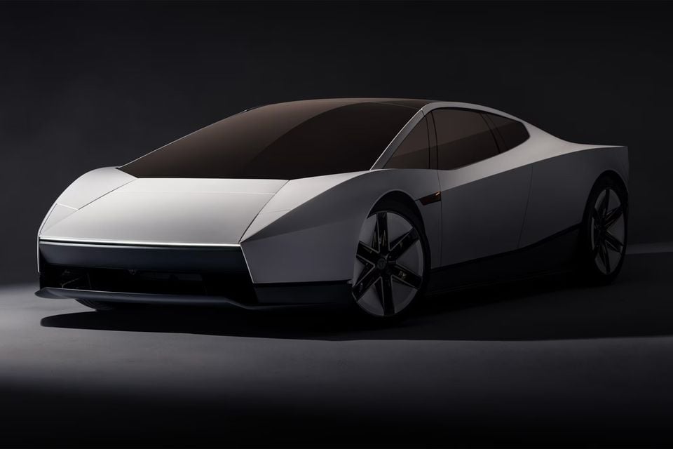 A white Tesla two-door electric concept car with a full-width front light bar, seen from the front quarter in a dark studio