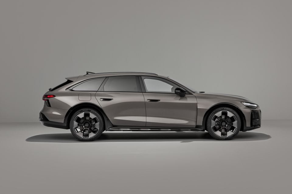 Um Audi A6 Allroad quattro wagon 2027 cinza bronze mostrado em perfil lateral em um estúdio cinza