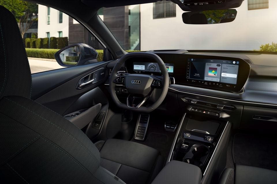 Interior of a 2027 Audi Q3 showing the steering wheel, digital instrument cluster, large widescreen infotainment display, and centre console
