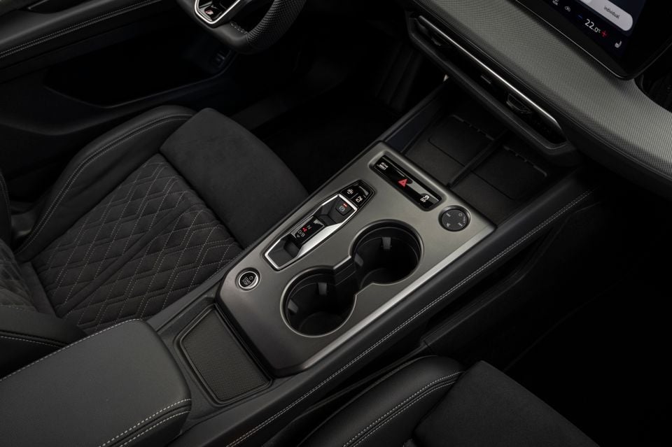 Interior centre console of the 2027 Audi Q4 e-tron showing the gear selector, cup holders, drive mode controls and climate buttons with diamond-stitched seats either side