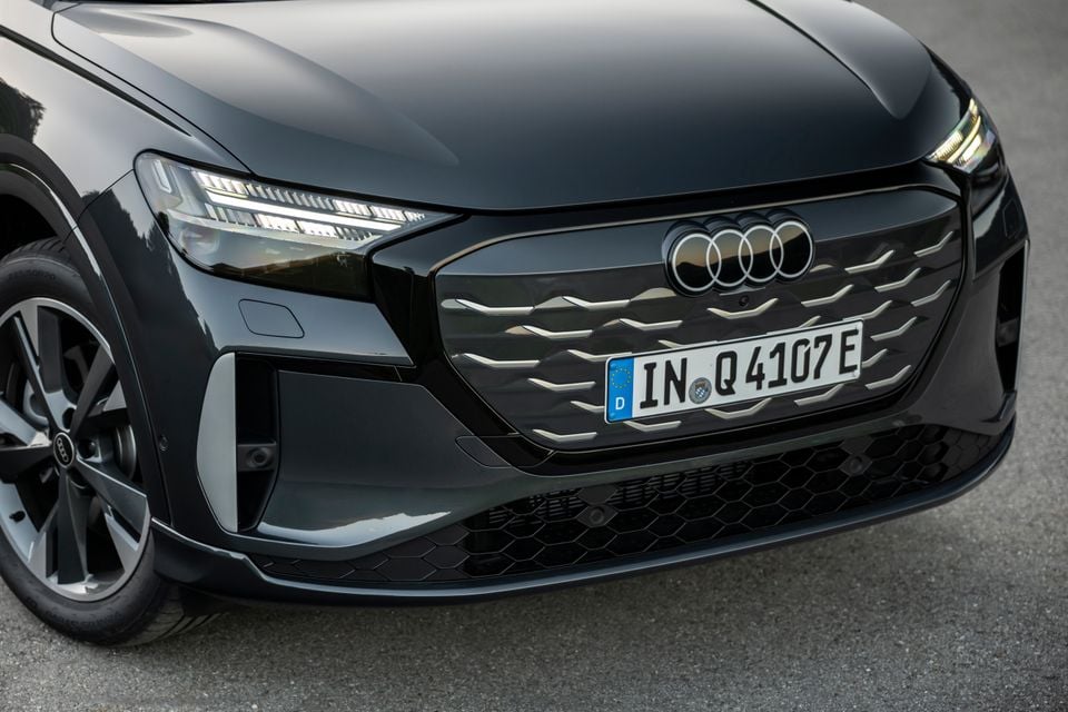 Close-up of the front grille and headlights of a dark grey Audi Q4 e-tron SUV with a German number plate