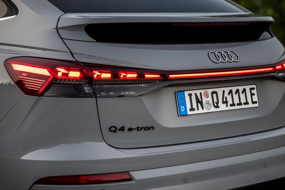 Rear of a grey 2027 Audi Q4 e-tron showing LED tail lights, Audi badge, and German number plate