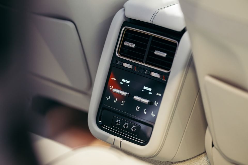 Console central traseiro do Bentley Batur 2027 mostrando controles de temperatura de zona dupla, saídas de ar, controles de assento e portas de carregamento USB-C com acabamento em couro creme