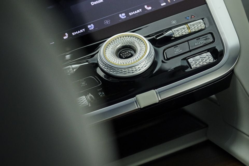 Close-up of a Bentley Torcal interior centre console showing a crystal-cut start/stop button with gold trim and climate control buttons