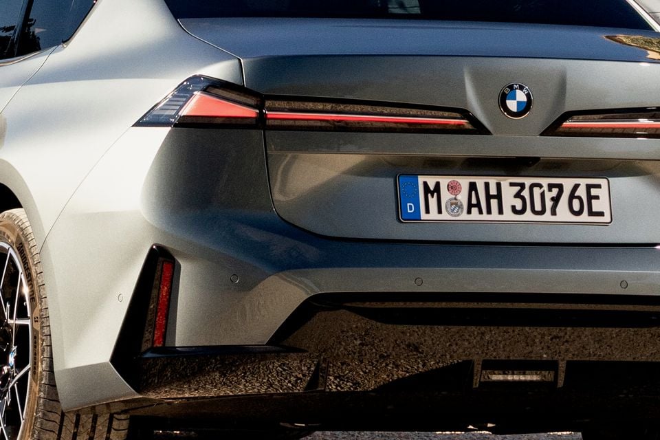 Close-up of the rear of a grey BMW sedan showing its slim LED tail-lights, BMW badge and German number plate