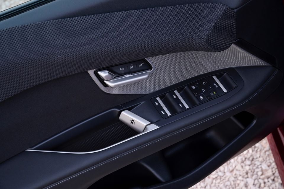 Door panel inside the 2027 BMW M350 with window switches, seat memory buttons, a metal door handle and perforated trim