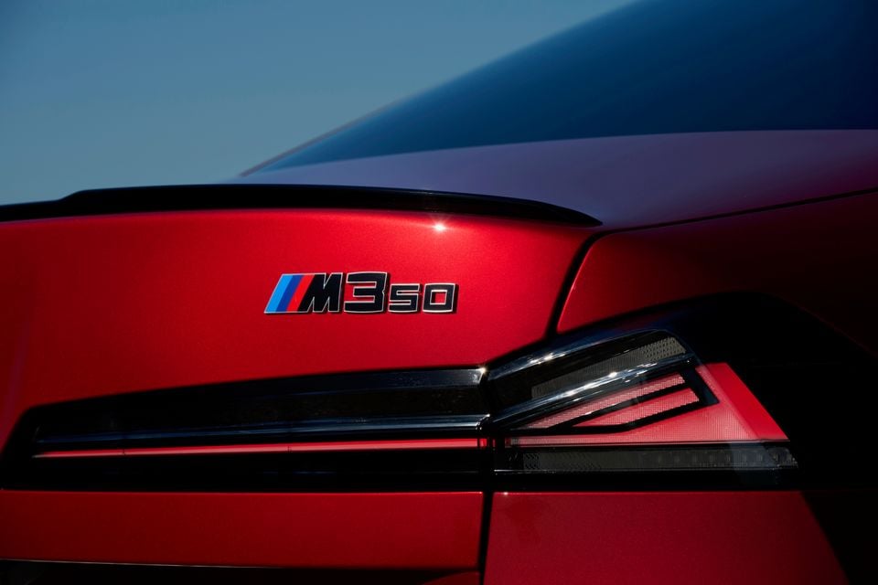 Close-up of the M350 badge and tail-light on the boot lid of a red 2027 BMW 3 Series sedan