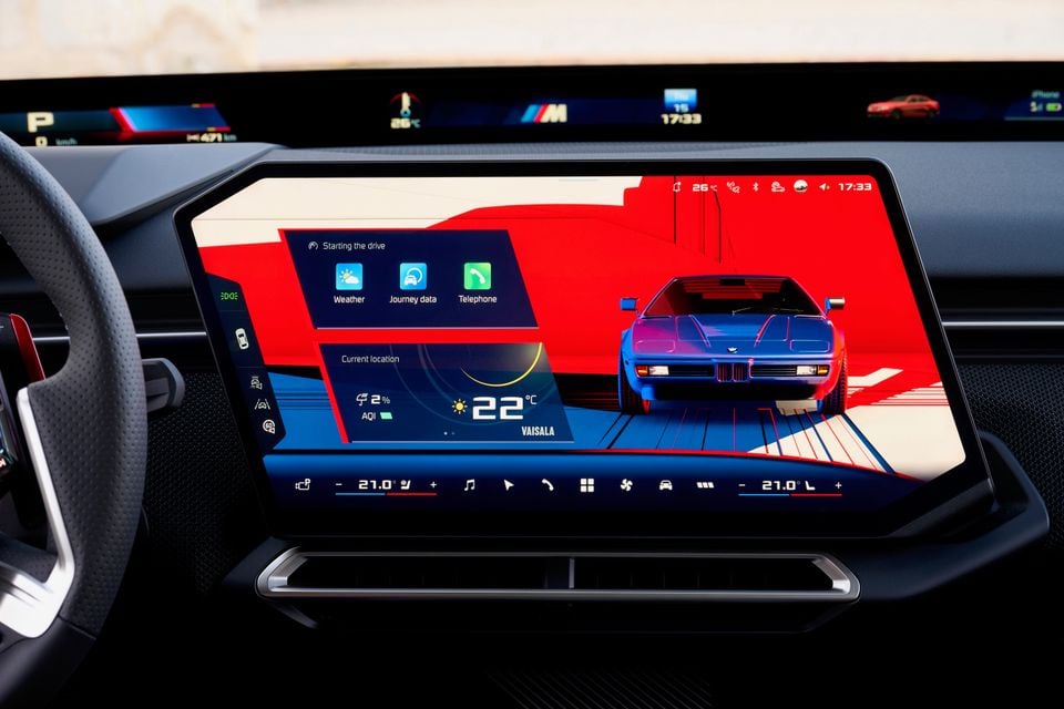 Central touchscreen in the 2027 BMW M350 3 Series showing a BMW M1 graphic, weather display and climate controls beneath a wide panoramic display