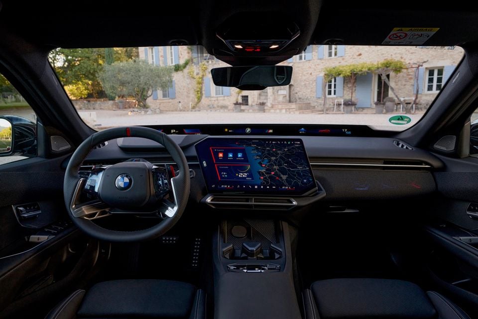 Dashboard of the 2027 BMW M350 3 Series showing the steering wheel, centre touchscreen with map, full-width display and front seats