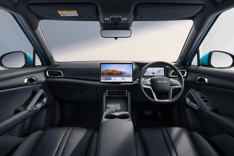 The interior of a BYD Atto 2 shows a black dashboard, steering wheel, touchscreen infotainment display and front seats.