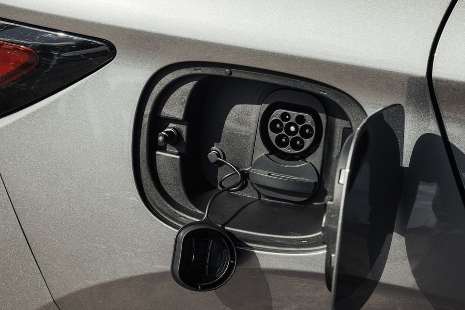 Close-up of the open charging port on a silver 2027 BYD Atto 3 Evo, showing the electric vehicle charging socket cover flap