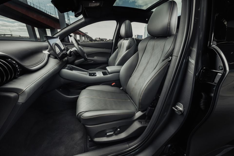 The black leather front seats and dashboard of a 2027 BYD Atto 3 Evo Premium, viewed from the open driver's door