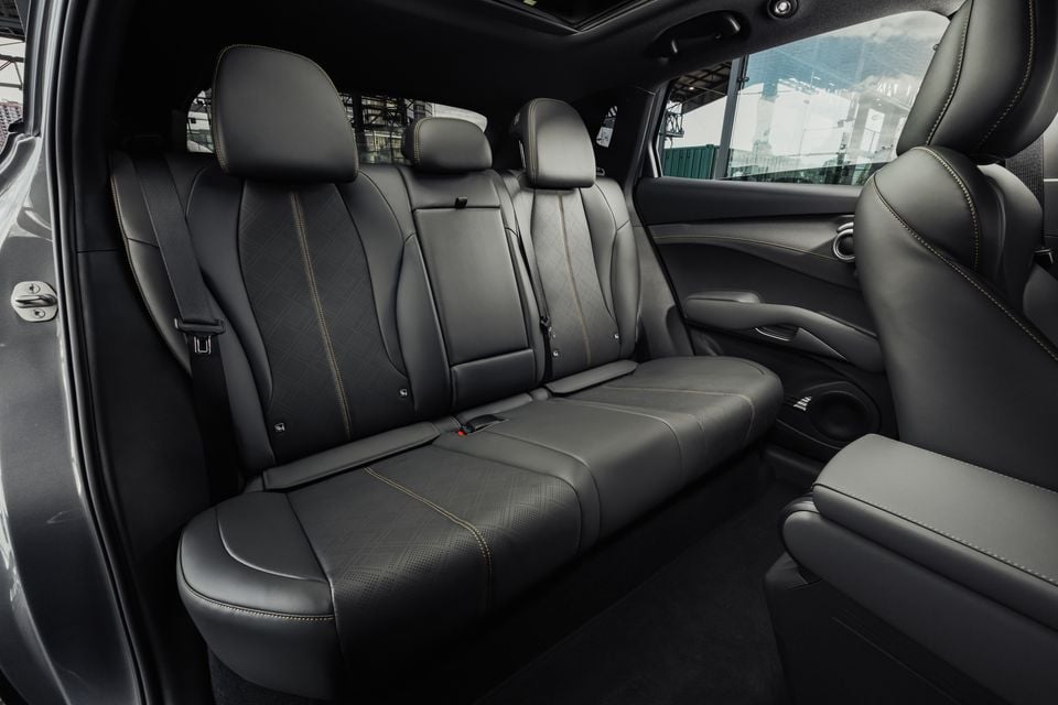 The black leather rear seats of a 2027 BYD Atto 3 Evo, viewed from the open door showing the bench seat and headrests.