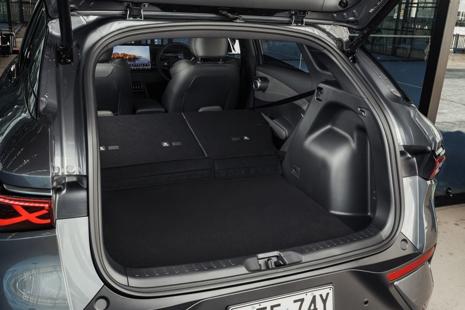 The open boot of a grey BYD Atto 3 Evo SUV, showing the expanded cargo space with the rear seats folded flat.