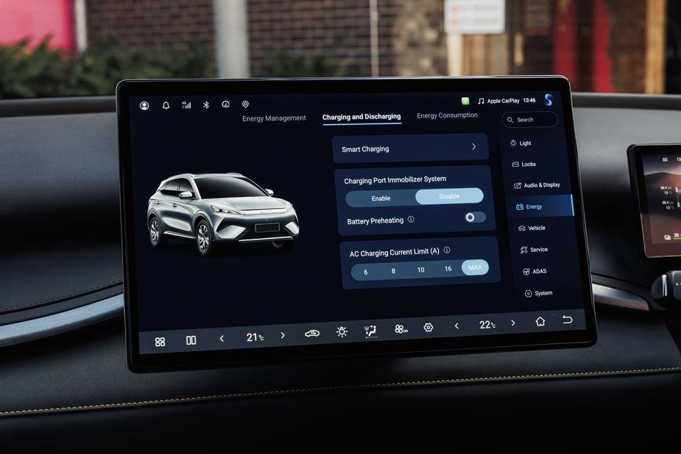 A car infotainment touchscreen displaying the Charging and Discharging energy management menu with a graphic of a BYD Atto 3 SUV