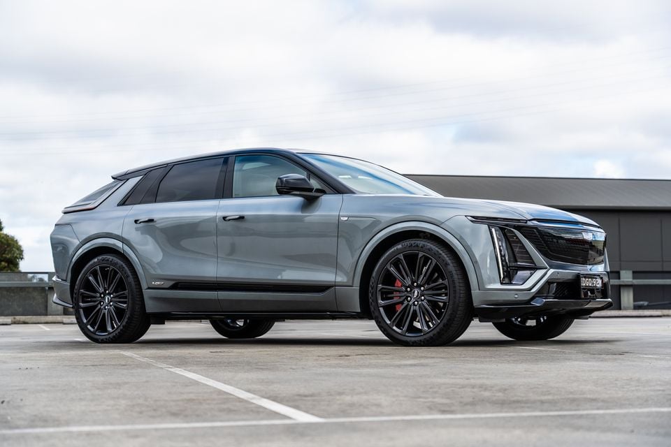 A grey 2027 Cadillac Lyriq V electric SUV seen from the front-side in a car park
