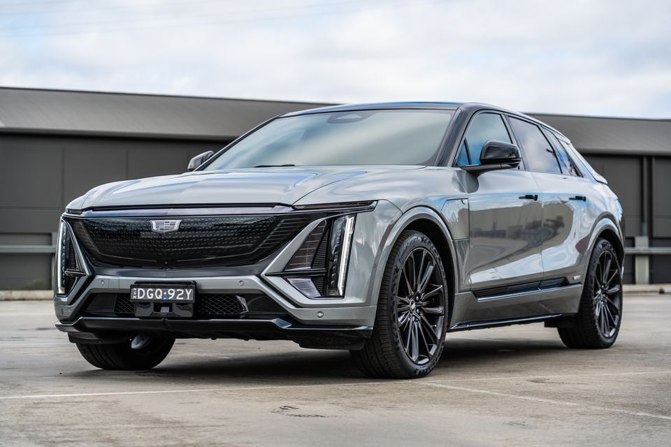 A grey Cadillac Lyriq electric SUV seen from the front three-quarter angle in a car park