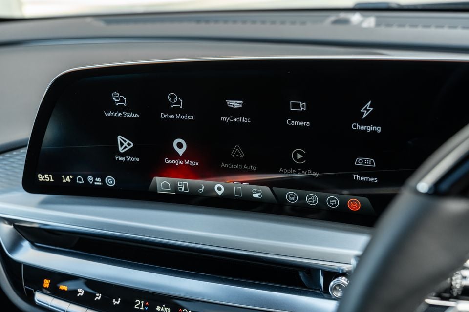 The Cadillac Lyriq's infotainment touchscreen displaying the home menu with options including Google Maps, Android Auto, Apple CarPlay, Drive Modes, Camera, and Charging