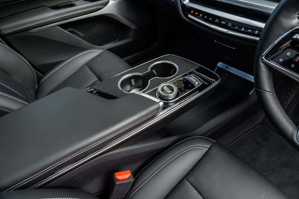 Interior view of a 2027 Cadillac Lyriq showing the centre console with cup holders, rotary gear selector, and climate controls on the dashboard