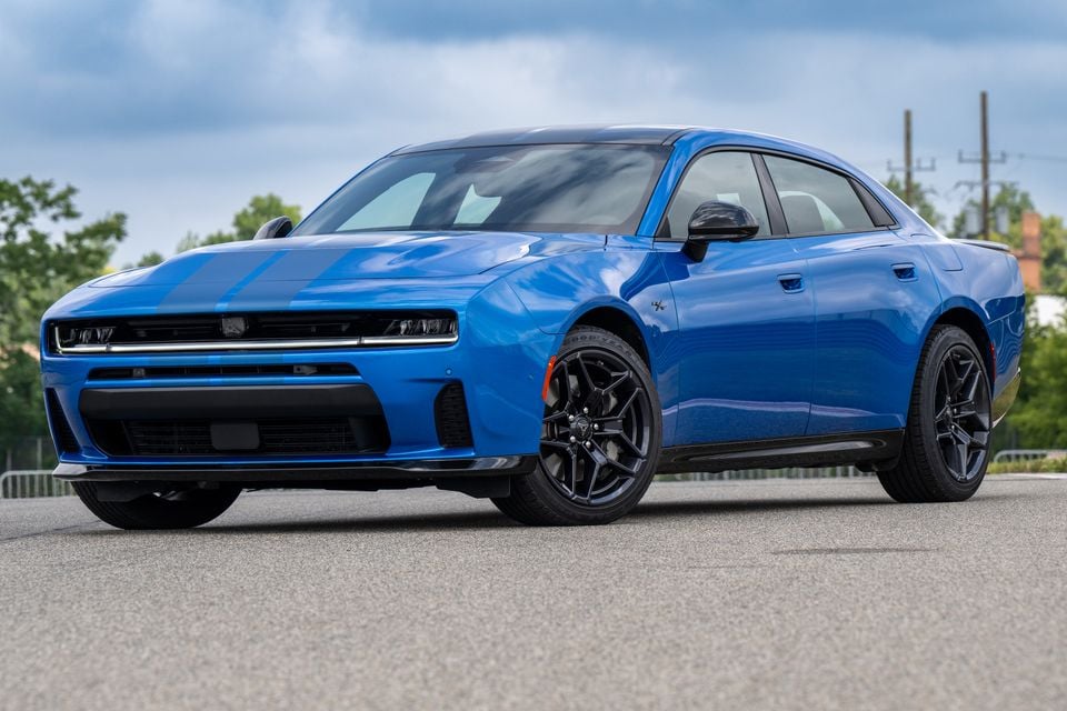 A blue 2027 Dodge Charger sedan seen from the front-side angle on a car park surface