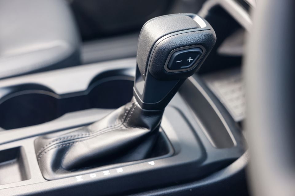 Close-up of the gear shifter with manual shift buttons in a Ford Everest, showing the leather-wrapped shift boot and centre console