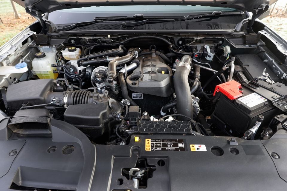 Engine bay of a Ford Everest showing a turbocharged 2.0-litre or 3.5-litre petrol engine with intercooler piping, battery, and fluid reservoirs visible