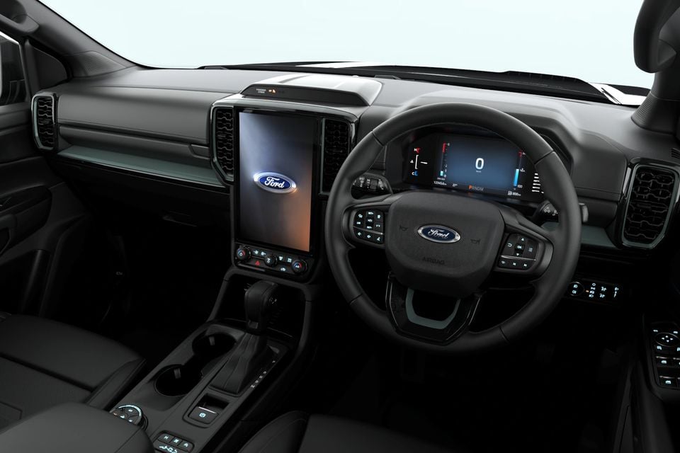 The interior of a 2027 Ford Everest Wolftrak showing the steering wheel, digital instrument cluster and central touchscreen with Ford logo