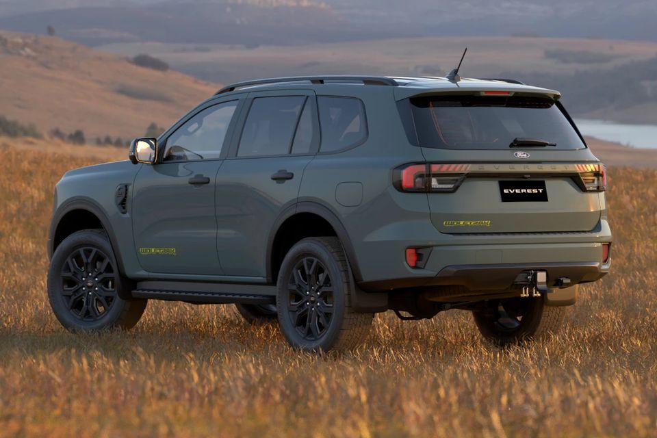 A grey 2027 Ford Everest Wolftrak SUV parked in a grassy field, seen from the rear quarter
