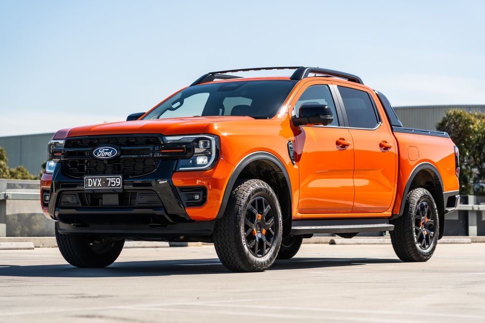 An orange Ford Ranger Wildtrak dual-cab ute seen from the front-side in a car park
