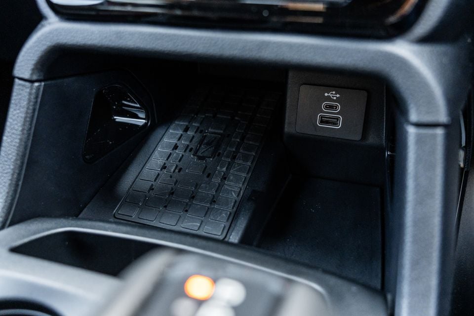 Close-up of the centre console storage area in a Ford Ranger Wildtrak, showing a wireless charging pad and USB-C and USB-A ports