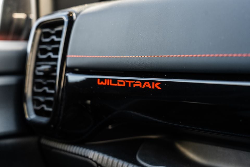 Ford Ranger Wildtrak dashboard trim panel showing an orange 'Wildtrak' badge with orange contrast stitching on the dashboard pad