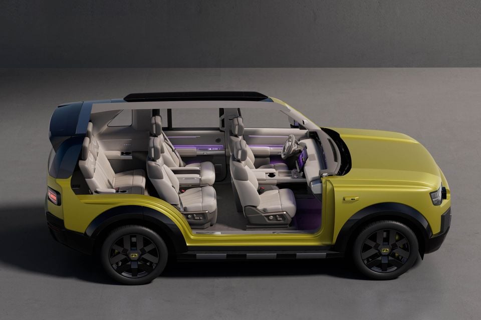 Cutaway side view of a yellow Land Rover Freelander concept SUV showing its three-row seating layout and interior with purple ambient lighting