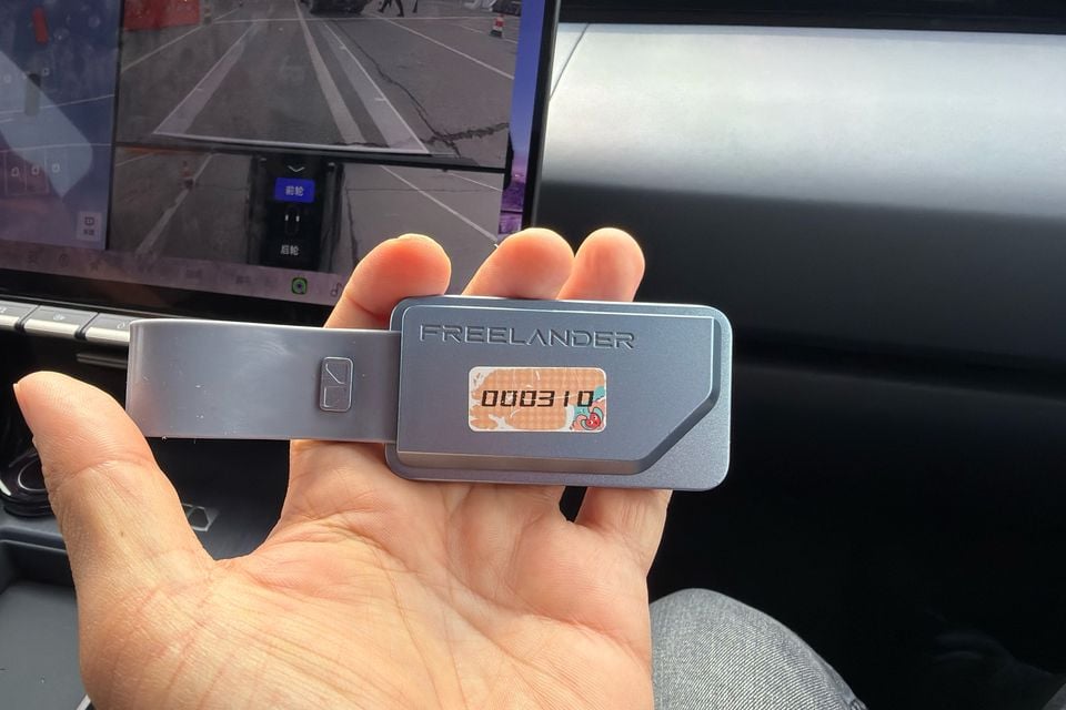 Reverse of a Freelander key fob held in front of the cabin display