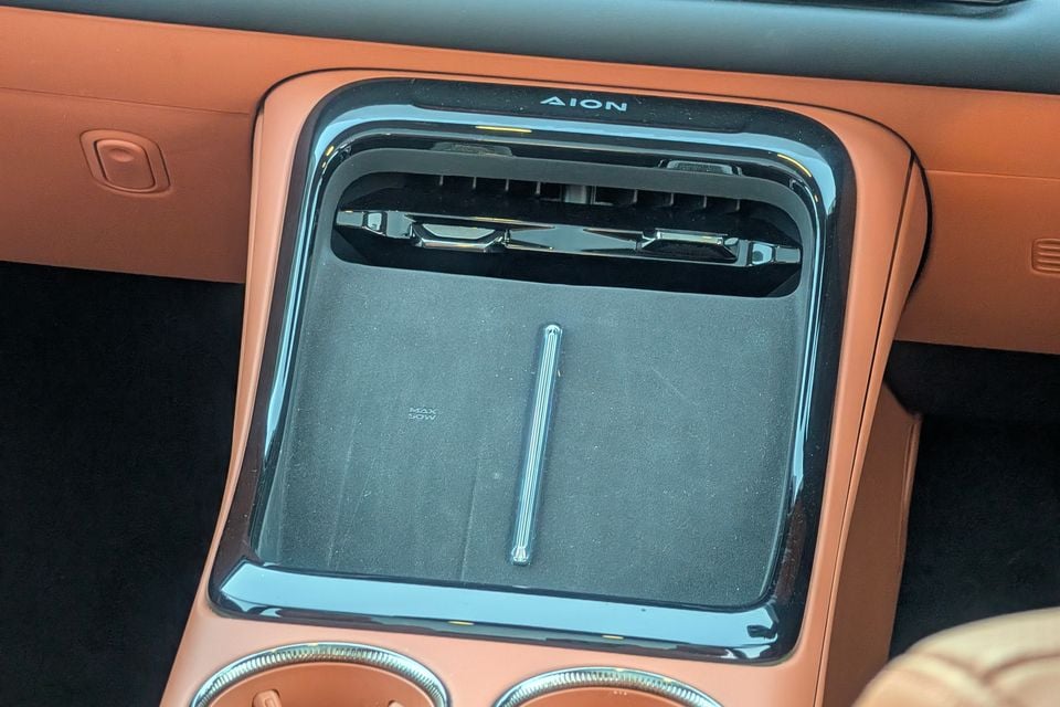 Close-up of the GAC Aion centre console showing a wireless charging pad with an air vent and Aion branding above it