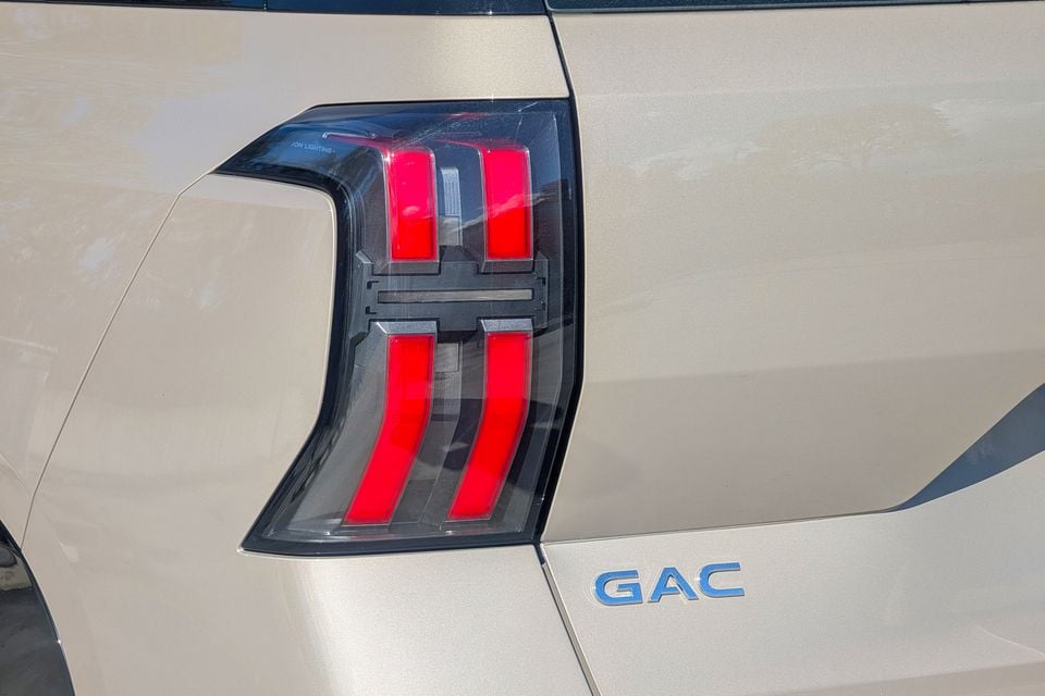 Close-up of the rear tail light and GAC badge on a beige GAC Aion V
