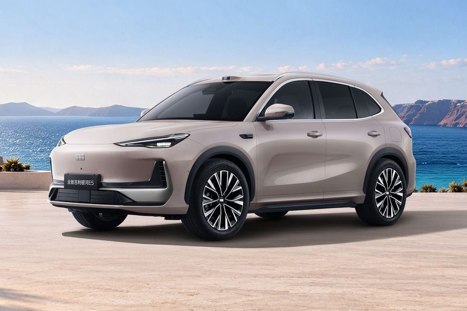 A beige Geely Galaxy E5 electric SUV parked on a coastal terrace, seen from the front quarter angle.
