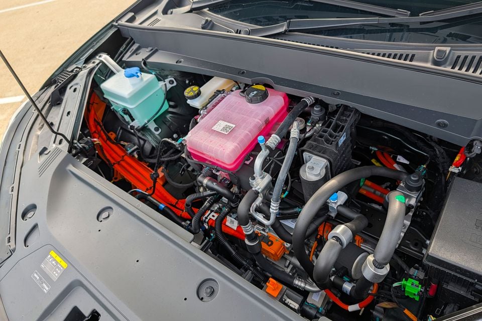 The engine bay of a Geely GX5 Inspire Extended Range, showing orange high-voltage cables and various fluid reservoirs with the bonnet open