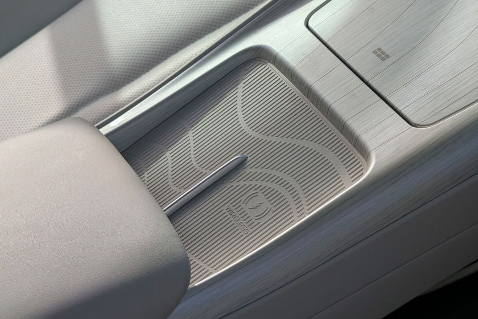 Wireless charging pad in the centre console of a Geely GX5 Inspire, with light grey trim and textured rubber mat