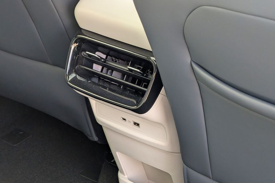 Rear air conditioning vent with chrome surround on the back of the front seat centre console, alongside USB-A and USB-C charging ports, in the Geely GX5 Inspire Extended Range