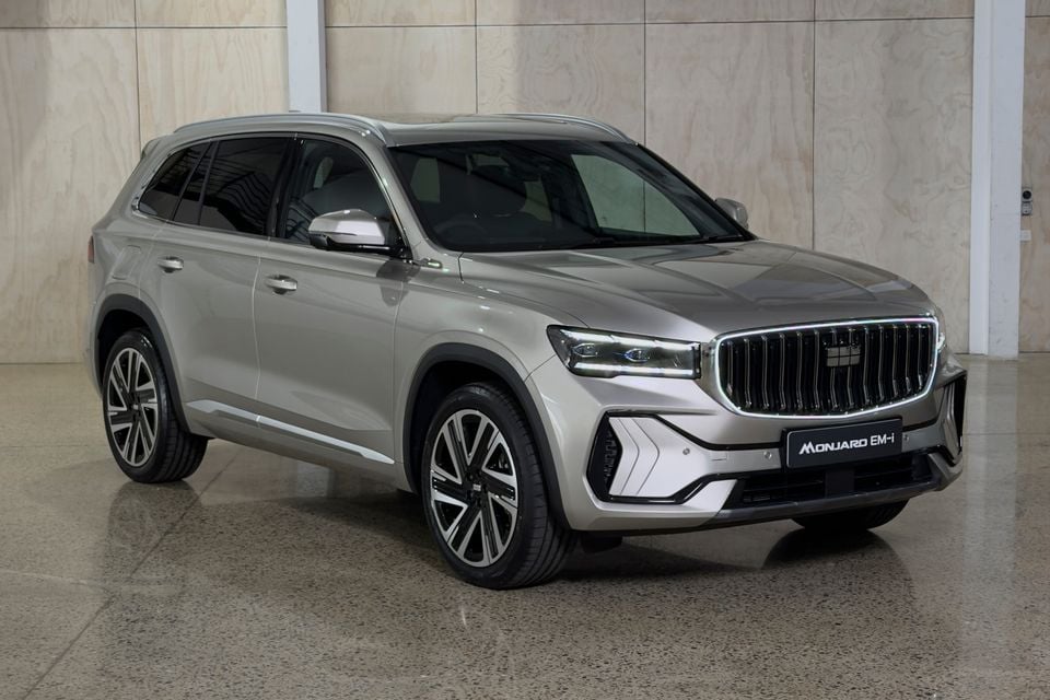 A silver Geely Monjaro EM-i SUV photographed from the front-side angle indoors