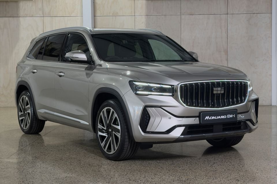 A silver Geely Monjaro EM-i SUV seen from the front-side angle indoors